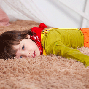 child lying on brown fur textile