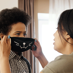 mother putting mask on child